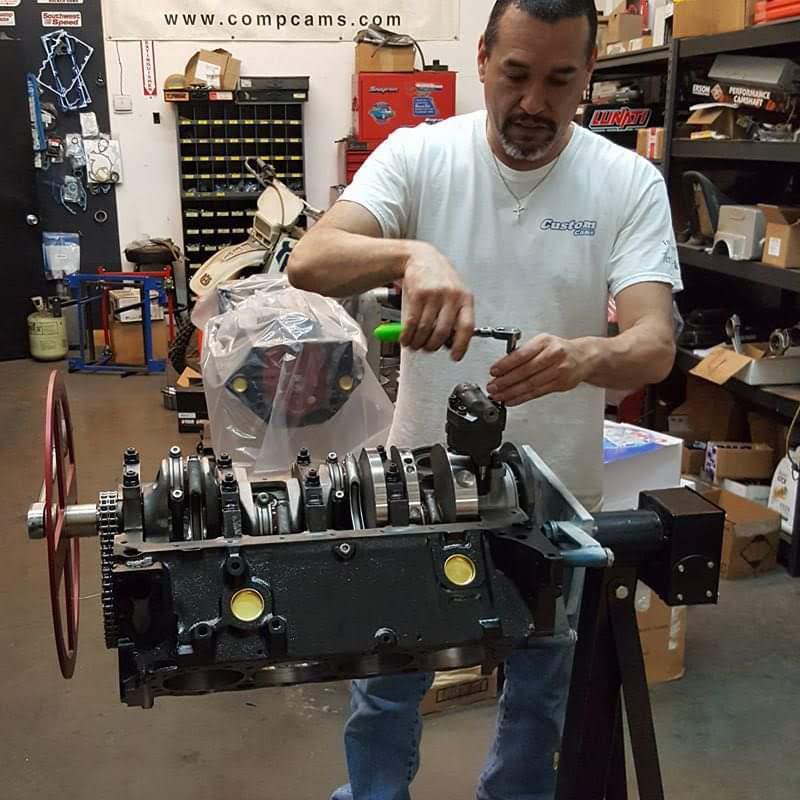 Bobby completing engine assembly during final stages of engine rebuild process