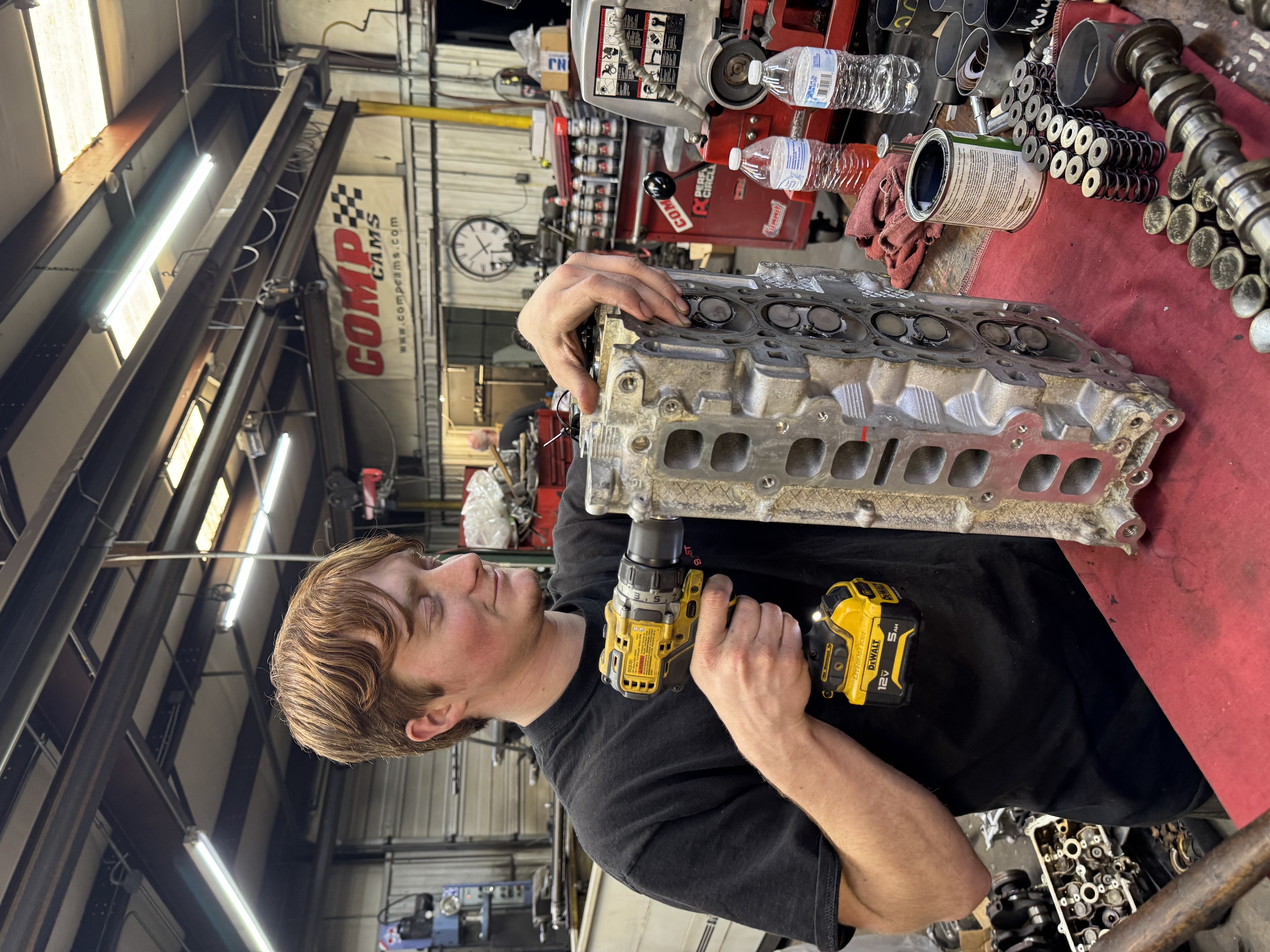 G&S Machine Shop technician lapping valves on a 2.4L engine cylinder head during precision cylinder head machining and engine rebuild service in Northwest Arkansas