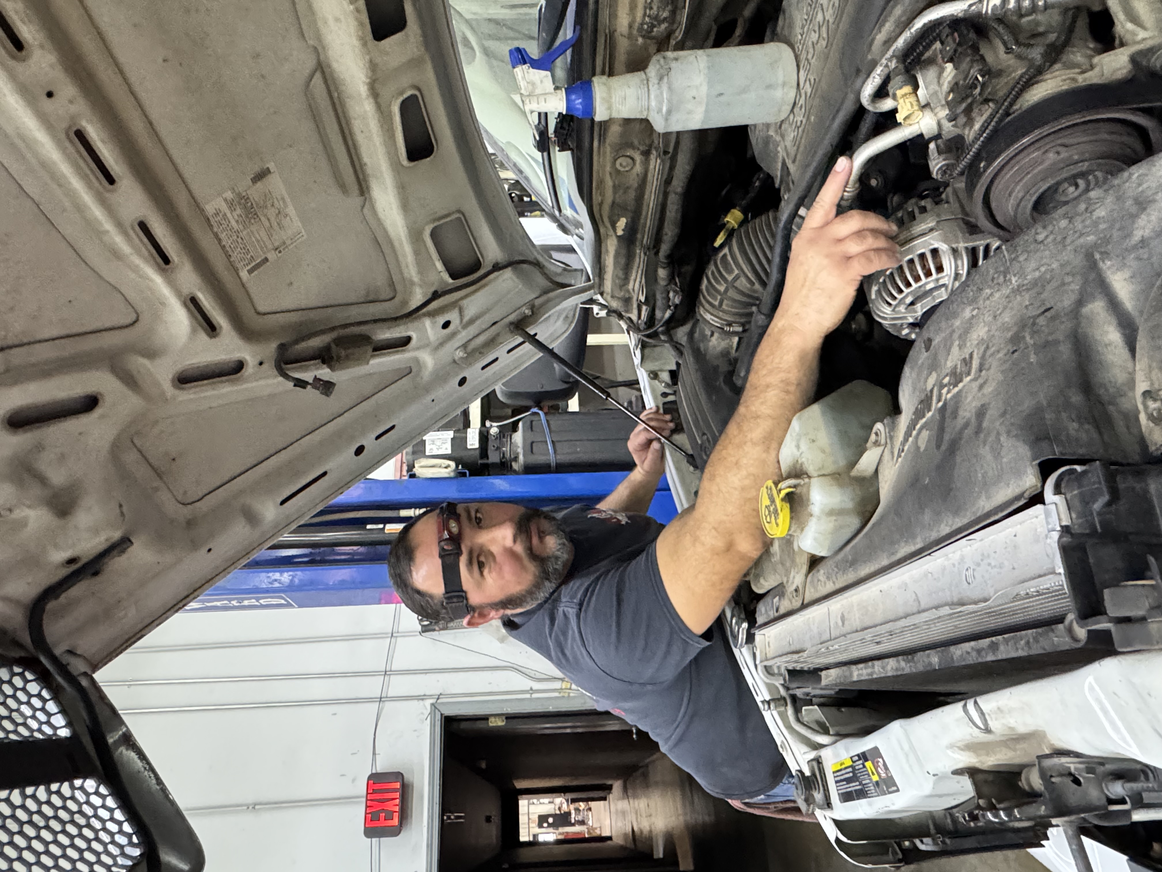 Technician performing AC system diagnostics on a vehicle